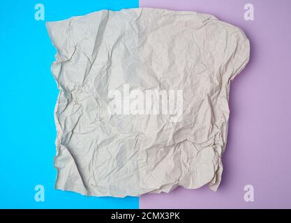 crumpled piece of gray paper on a colored background, top view Stock Photo
