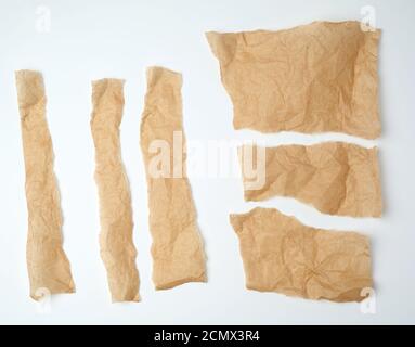 torn brown pieces of parchment paper on a white background Stock Photo