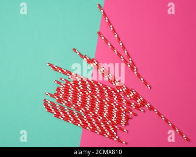red paper tubes for a cocktail on a multi-colored background Stock Photo