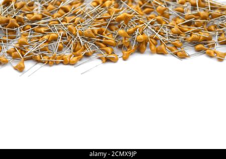 Lot of yellow capacitors are located on top with copy space. Electronic components isolated on a white background, selective focus. Stock Photo