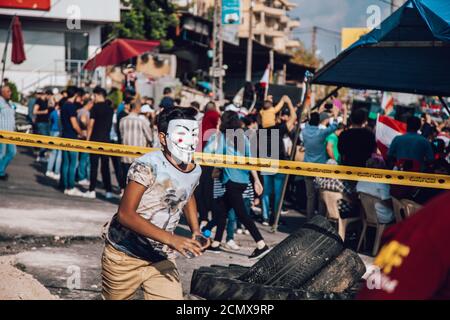 Nabatieh, South  / Lebanon : Lebanese Protesters Revolution against the Government | a kid running wearing Guy Fawkes Mask