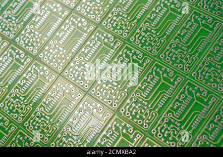 Close-up of a green electronic circuit boards positioned diagonally as a background, selective focus. Concept for development of electronic circuits Stock Photo