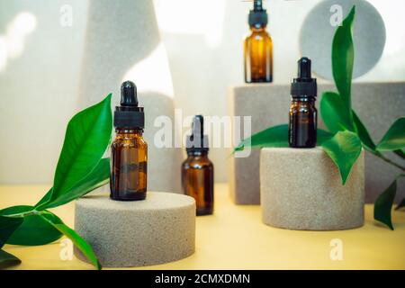 Creative background of geometric shapes with natural cosmetic essential oils bottles. Beauty and body care product concept on trendy stands or podiums Stock Photo
