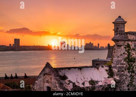 Beautiful sunset in Havana with a view of the city skyline and the sun setting over the buildings - Seen from an El Morro castle across the bay Stock Photo