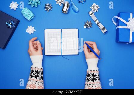 open notebook with empty white sheets and two female hands Stock Photo
