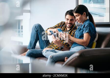 Man Teaching Phone App Technology To Girlfriend With Smartphone Stock Photo