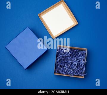 open brown square cardboard empty box, item lies on a blue classic background Stock Photo