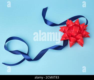 blue silk thin ribbon twisted on a blue wooden background, trendy ...