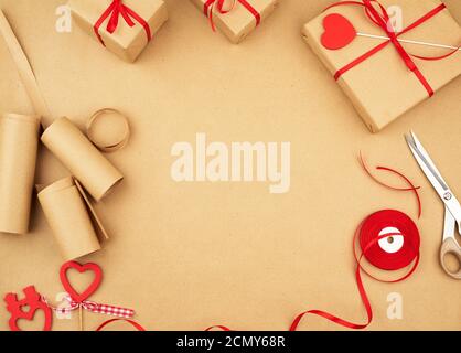 brown kraft paper, packed gift bags and tied with a red ribbon Stock Photo