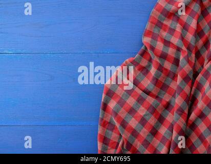 red checkered fabric on a blue wooden background Stock Photo