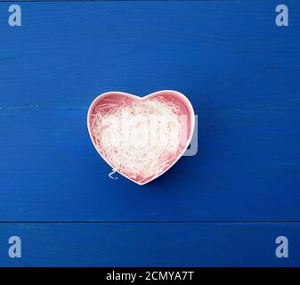 open empty heart-shaped box on a blue wooden background Stock Photo