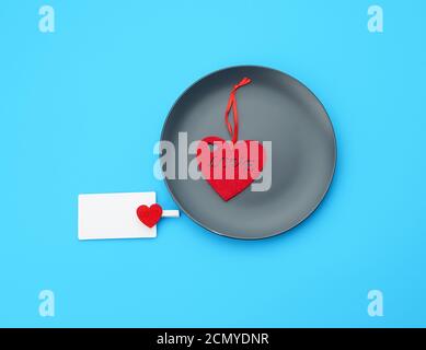 empty round gray plate and decorative red heart, next to an empty white business card Stock Photo