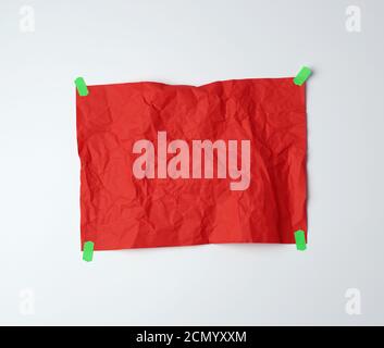 empty red crumpled sheet of paper glued with green sticky pieces of paper Stock Photo