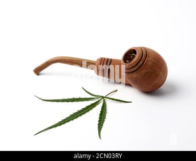 wooden smoking pipe and green hemp leaves on a white background, concept of  legalization of marijuana for alternative medicine Stock Photo - Alamy