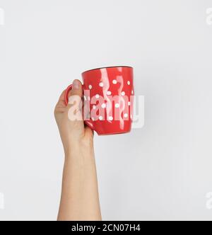 red ceramic cup in a female hand on a white background Stock Photo