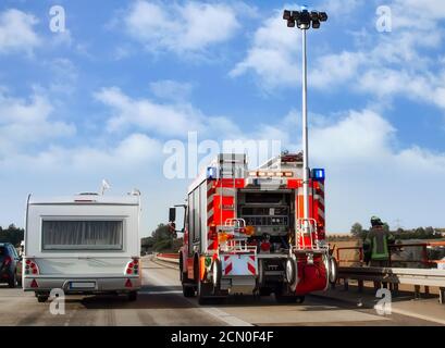 Fire truck with extended lighting mast on the highway in Germany. Securing an accident site Stock Photo