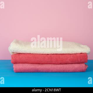 stack of pink folded towels on a blue background Stock Photo
