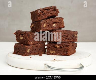 stack of square baked slices of brownie chocolate cake with walnuts Stock Photo