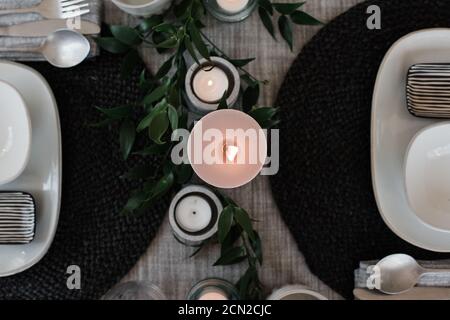 sky view of a large candle on a dinner table setting for two Stock Photo