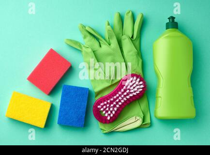 green rubber gloves for cleaning, multi-colored sponges, brushes and cleaning fluid Stock Photo