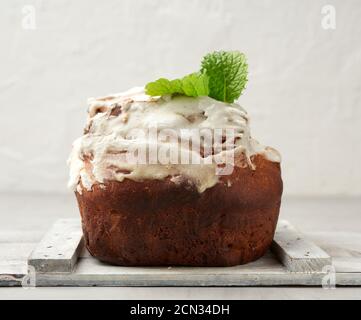 baked Easter cake with white lemon glaze on a white wooden board Stock Photo