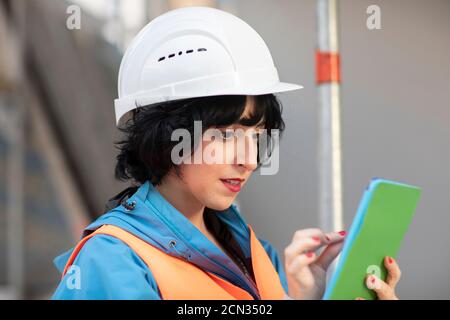 young construction engineer  female with helmet working outside Stock Photo