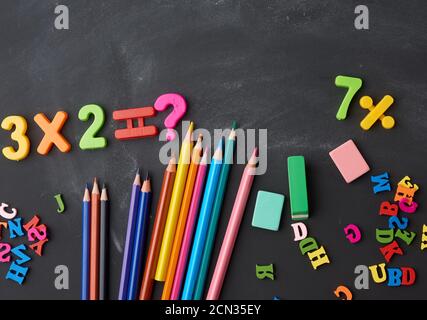 wooden multi-colored pencils, plastic numbers on a black background Stock Photo