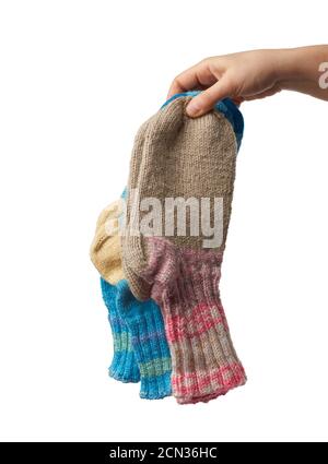 female hand holds a pair of knitted woolen socks, warm clothes