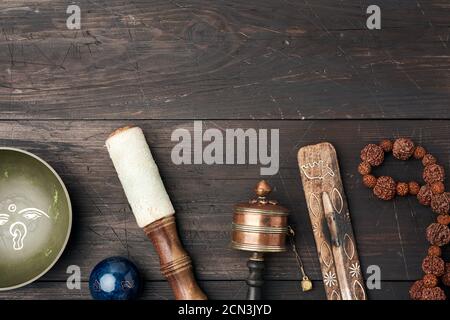 Copper singing bowl, prayer beads, prayer drum and other Tibetan religious objects for meditation an Stock Photo