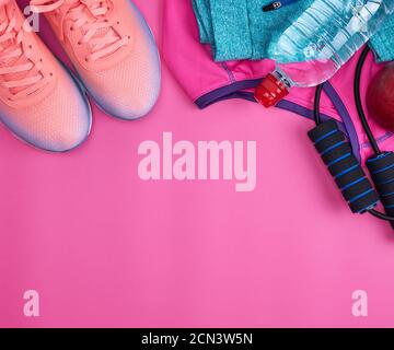 jump rope, bottle of water, pink sneakers, clothes for sports and fitness Stock Photo