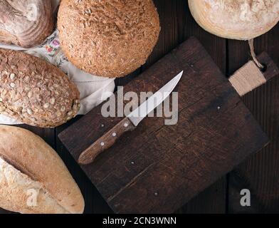 baked various breads on a beige kitchen towel, wooden background Stock Photo