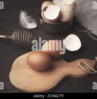 brown whole chicken eggs on a wooden board Stock Photo