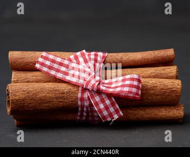 tied bunch of brown cinnamon sticks on a dark background Stock Photo