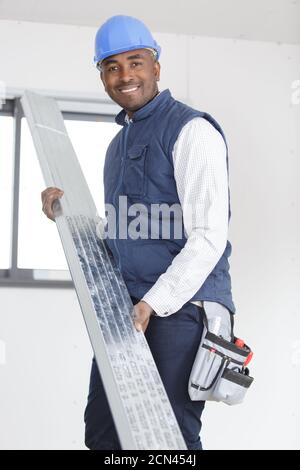 builder carrying metal support Stock Photo