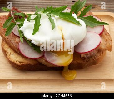 sandwich on toasted white slice of bread with poached eggs Stock Photo
