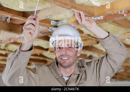 construction worker thermally insulating eco wooden frame house Stock Photo