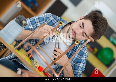 plumber working on copper central heating pipes Stock Photo