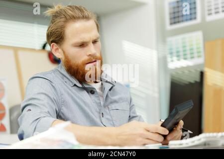 man using a calculator in an office Stock Photo