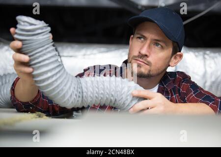 worker inspects the wiring for ventilation Stock Photo