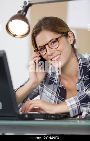 casual woman with phone working on desk Stock Photo