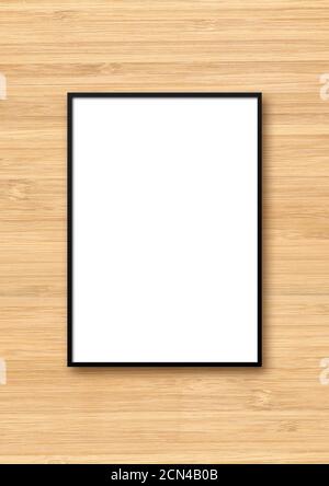 Black picture frame hanging on a light wooden wall Stock Photo