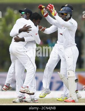 Sri Lanka's Tharindu Kaushal (L) celebrates with captain Angelo Mathews (2nd L) and Dinesh Chandimal (R) after taking the wicket of India's Shikhar Dhawani (not pictured) during the fourth day of their first test cricket match against Sri Lanka in Galle August 15, 2015. REUTERS/Dinuka Liyanawatte