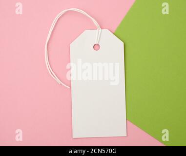 white paper rectangular tag on a rope on a colored background Stock Photo