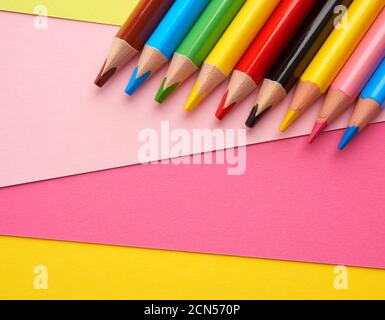 sharpened colored wooden pencils on an abstract background of cardboard Stock Photo