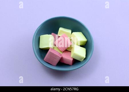 Fruit juice chew candies in small blue candy bowl on lavender background Stock Photo
