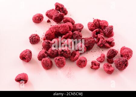 Pile of freeze dried red raspberries fruit on pink background Stock Photo