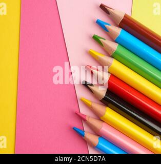 sharpened colored wooden pencils on an abstract background of cardboard Stock Photo