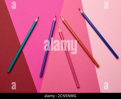 sharpened colored wooden pencils on an abstract background of cardboard Stock Photo
