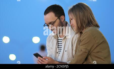 Smart boy showing something on his phone to his girlfriend. Stock Photo