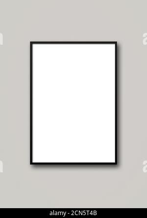Black picture frame hanging on a light grey wall Stock Photo